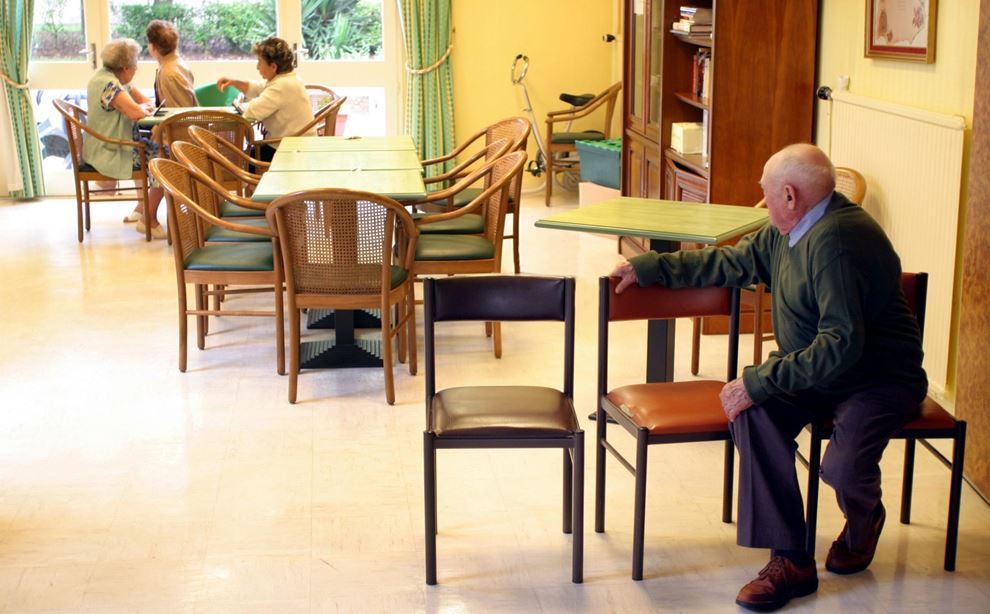 Ældre sidder på stole på plejehjem