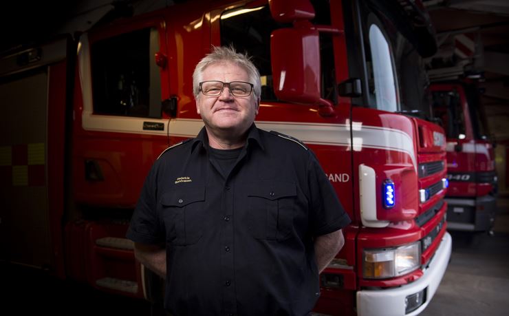 Brandmand Søren Andersen foran en brandbil