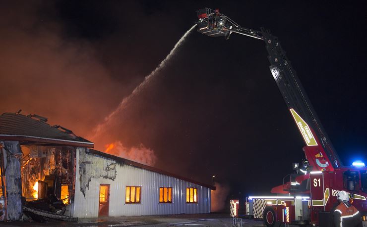 Brandstigen sprøjter vand på en brændende bygning