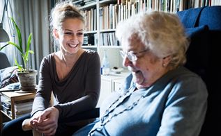 Social- og sundhedshjælper taler med ældre kvinde