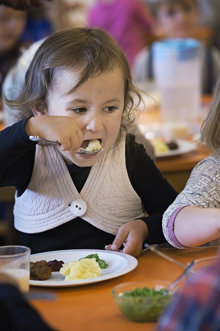 Barn spiser köttbullar i institution