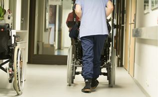 Medarbejder på plejecenter skubber beboer i kørestol