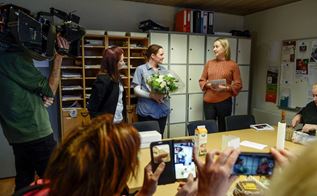 Gitte overrækker blomster til vinderen af årets kollega