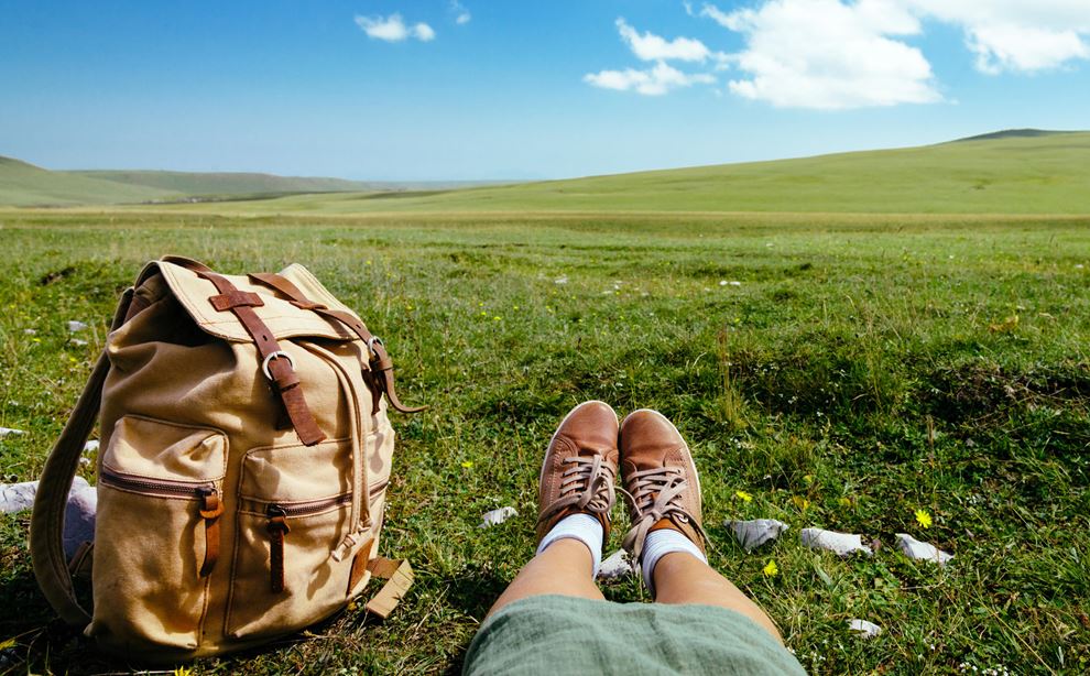 Taske og ben på græsplane foto: Colourbox
