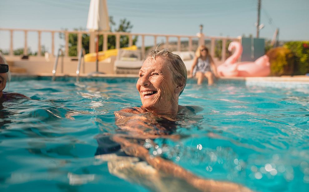 Ældre kvinde holder hovedet oven vande i svømmebassin