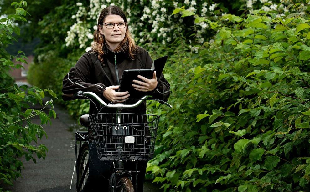 Social- og sundhedshjælper Maria Busborg Jørgensen med en cykel og en ipad foto: Jørgen True