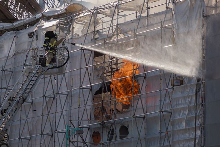 Brandmand sprøjter vand på Børsen, som brænder