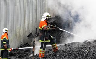 Brandmænd står i røg og sod