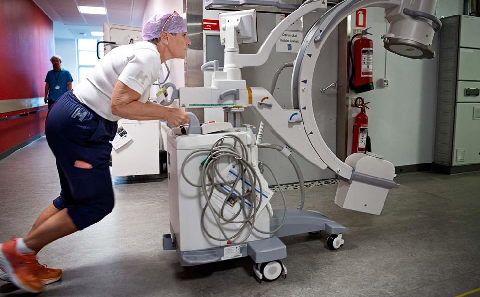 Serviceassistent ruller en røntgenmaskine
